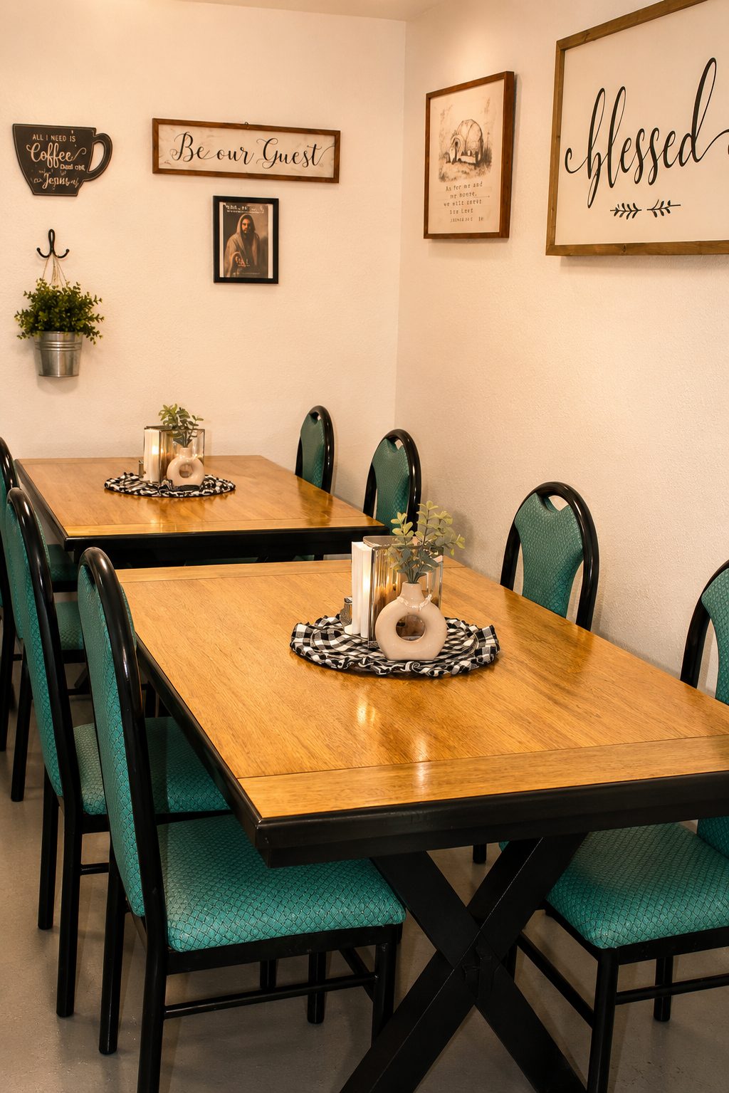 Interior dining tables with teal chairs beneath “Be our Guest” and “blessed” signs
